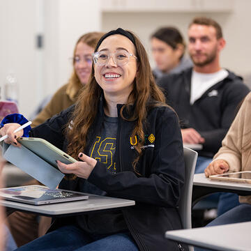 student sitting at desk laughing