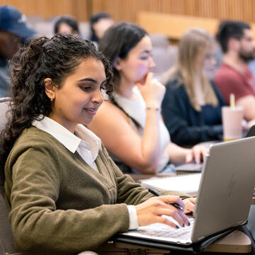 USF student in class taking notes on laptop