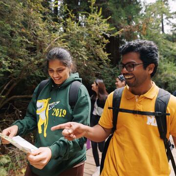 Two students walking and looking at a map