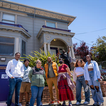 groupf of usf students standing in front of a victorian house in san francisco