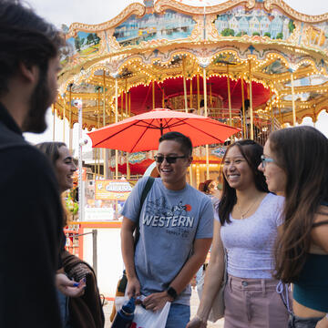 students laughing together with carousel behind them