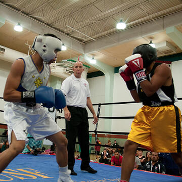referee looks on as two students box