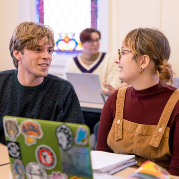 two students smile at eachother in class