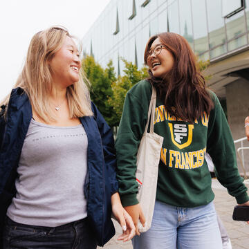 Two students walk across main campus