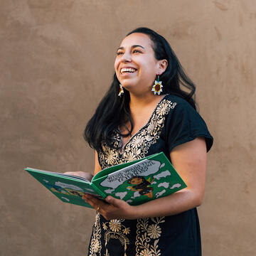 student happily holds book open