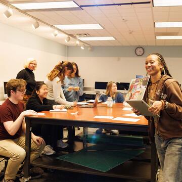 Students in a classroom looking at a laptop