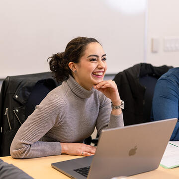 student sitting with laptop in class