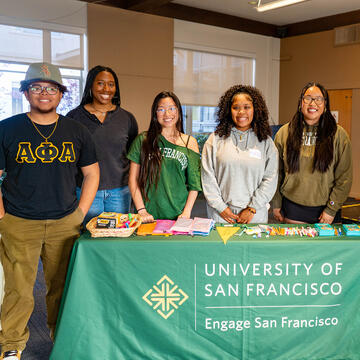 students stand behind booth