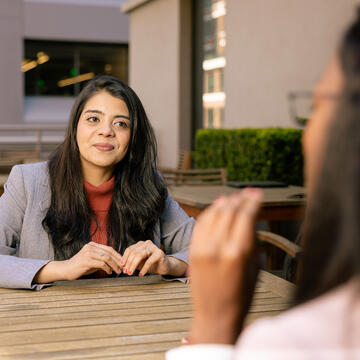 student in business attire sits outside