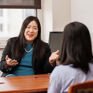 Two people talking in an office at a desk