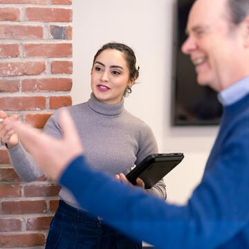 student and teacher use blackboard in front of class