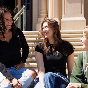students sit together on steps