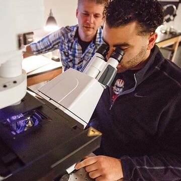 Student working in a lab with a professor