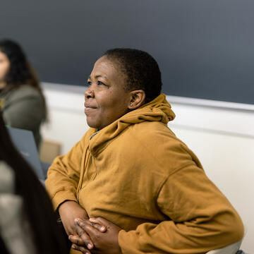 student in hoodie smiling in class