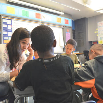 teacher helps young students in class