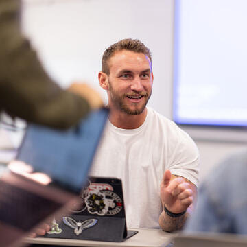 student speaks in class in front of laptop