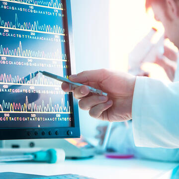 Technician looks at DNA sequence on a computer