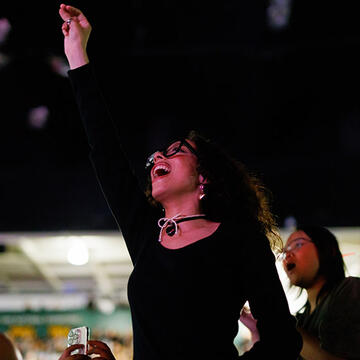 student raises arm in air