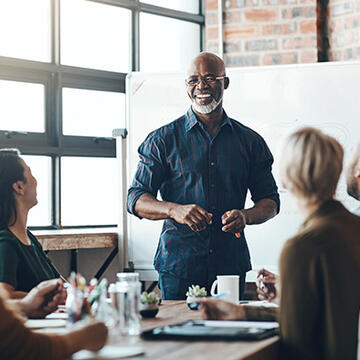 Leader standing in front of colleagues in office room