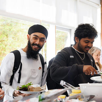 Two USF students helping themselves to food at a buffet