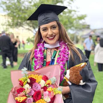 Maria Membrila holding flowers after graduating.