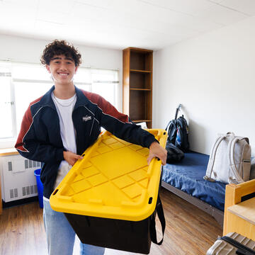 Student unpacking in new residence hall room