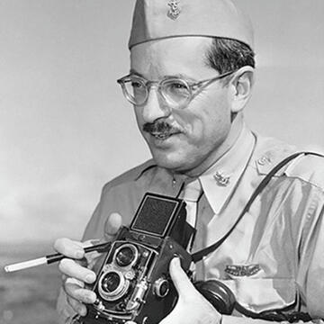 World War 2 photographer holding camera.