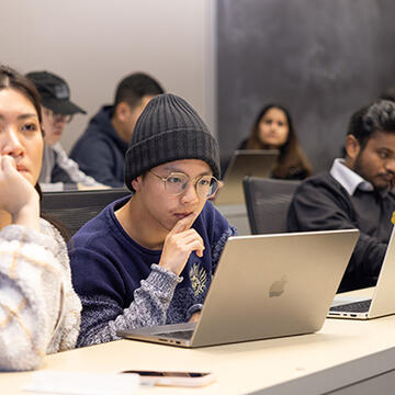 Students in classroom looking at laptops