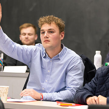 Student raising their hand in class