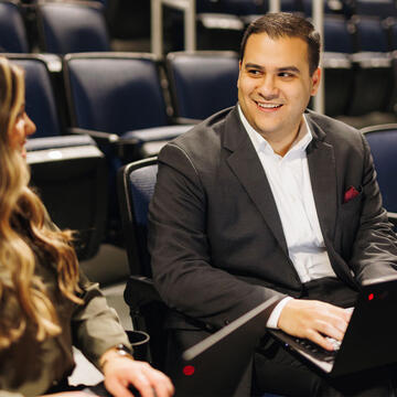 Two students chatting in Chase Center, wearing business attire