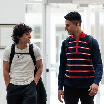 Two students chatting in the School of Law building