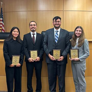 Four students standing in moot court