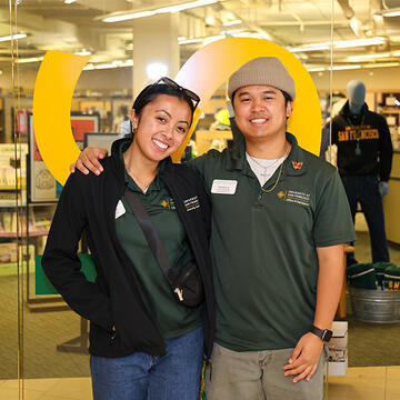 Two students posing in front of USF's Bookstore