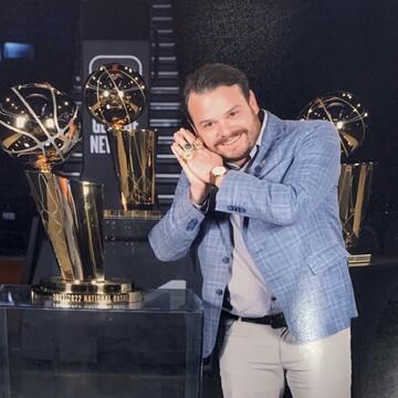 Thomas Sweeney posing next to basketball trophies