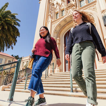 two students walking down stairs outside