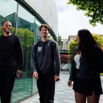 Three students walking and talking to each other