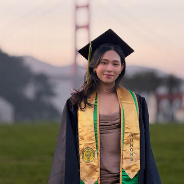 Student poses in graduation regalia