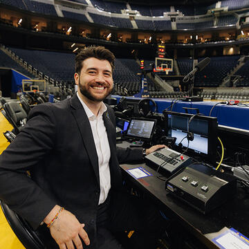 Worker behind the announcers desk at Chase Center