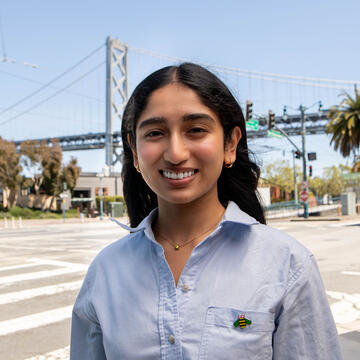 USF student posing in front of the Bay Bridge