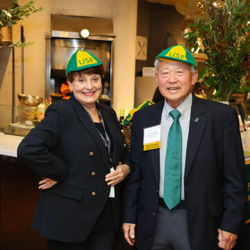Two people from USF 1970 and 1975 reunion in vintage USF hats