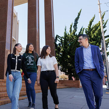 students walk with professor outside