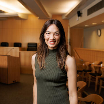 Law student smiling in practice courtroom