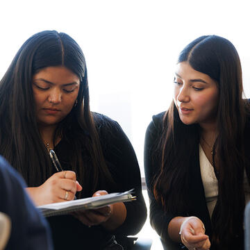 two students take notes together