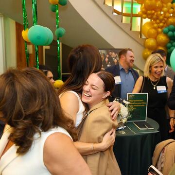 people hugging at a School of Law alumni reunion