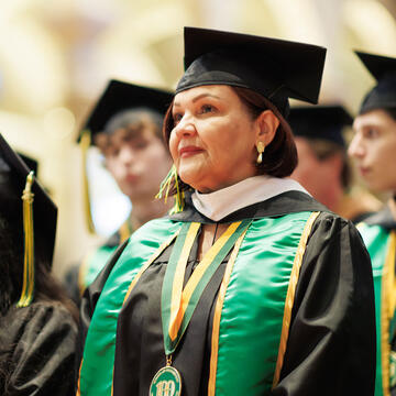 A graduate stands at attention during commencement ceremonies