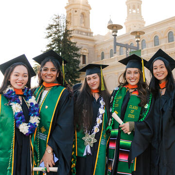 Group of new grads in their regalia pose
