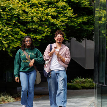 two students walk together outside on usf campus