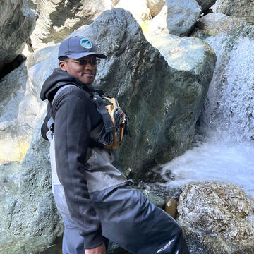 Brian Ohiaeri takes measurements in a creek waterfall