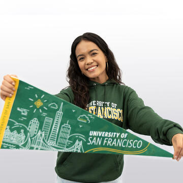 Admission counselor holds a USF penant