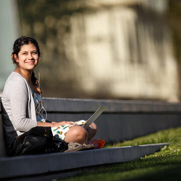 Student with laptop outdoors